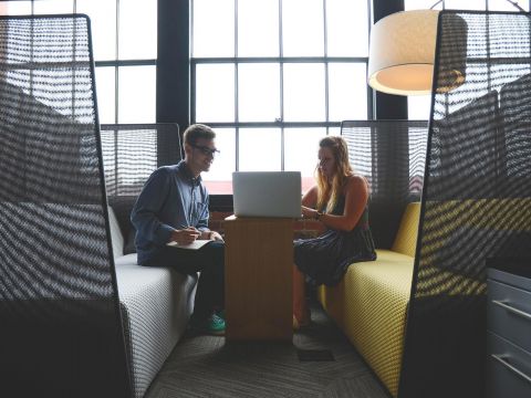 Zwei junge Menschen schauen zusammen in einen Laptop