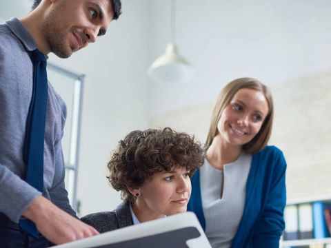 Drei Mitarbeiter im Meeting mit einem Kollegen über Skype for Business