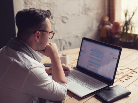 Mann sitzt vor Laptop und hat Lync geöffnet