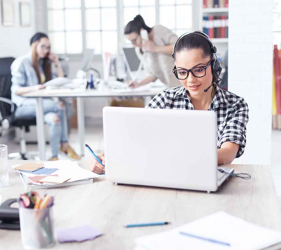 Junge Frau mit Headset am Computer